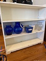 Shelf displaying the assorted vases and glass containers, confirming item details and varieties