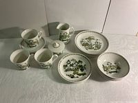 Overall view of lunch plates, bowls, cups, saucers, cream pitcher, sugar bowl with lid, and dessert plates with Market Place pattern.