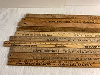 Top view showing close arrangement and printed advertisements on wooden measuring sticks.