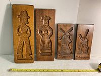 Front view of four carved wooden cookie molds from Holland showing man, woman, and two windmills (Wipmolen, Poldermolen) designs with measurement tape for scale.