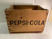 Front side of the wooden crate with visible PEPSI-COLA lettering in black paint.