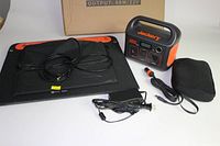 Overview of Explorer 240 power station, SolarSaga panel, cables and pouch on white background