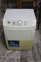 Full view of Kenmore 35 pint dehumidifier showing control panel and front grille on tile floor.