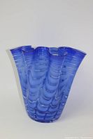 Front view of large blue Murano glass vase with ruffled handkerchief style top edge showing wave-like patterns throughout the glass.