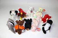 Front view of 10 vintage Ty Beanie Babies plush toys including dog, turkey, bear, moose, penguin, and others.