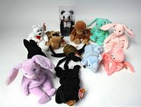 All 12 vintage Beanie Babies arranged in group, showing various animals including bunnies, bear, monkey, moose, bat, octopus, elephant, and panda in display box. Most retain original Ty tags.