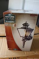 Photo of sealed box showing Secure Home Heath Zenith branding and motion activation feature