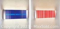 Photo of the mounted barcode light fixtures, one blue and one red, lit on wall
