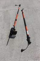 Full view of the Remington electric pole saw with two detachable poles shown separated on ground.