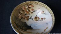 Close-up photo showing the floral cherry blossom design on the inside of the porcelain dish with gold accents.