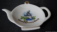 White ceramic teapot shaped dish with Walt Disney World castle logo and gold lettering