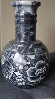 Close-up of the large black marble vase showing the white etched floral pattern
