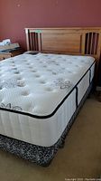 Front view of wooden headboard with mattress and box spring in bedroom setting