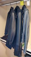 Three leather jackets hanging on rack showing side and partial front views.