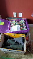 Purple storage bin filled with folded fabric pieces