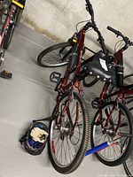 Overall view of the bike alongside the helmet on the floor, showing bike frame and tires