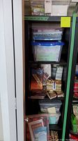Photo of shelving unit with multiple clear and opaque storage containers holding quilting fabrics, including a blue-lidded container labeled 'Christmas'.