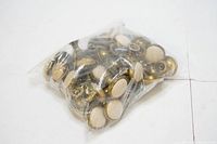 Bag containing approximately twenty-two sets of vintage cupboard knobs and latches made of brass-colored metal and wood centers.