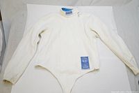 Full view of white fencing jacket with long sleeves and high collar