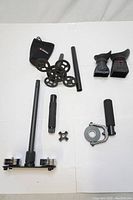 Top-down view of all items laid out on white surface including rods, weights, eyepiece covers, mounting parts and a small black protective bag.