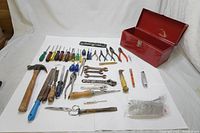 Full overhead view of the red metal tool box with assorted vintage hand tools laid out