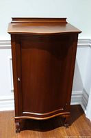 Front view of closed cabinet showing single door and key in lock