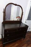 Full view of antique wooden dresser with attached large mirror showing drawer details and mirror design.