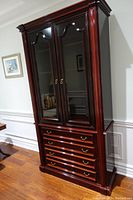 Front view of the assembled china cabinet showing closed glass doors and four lower drawers.