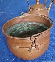 Copper pot showing interior green patina and metal handles