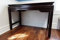 Side front view of the wooden hall or computer table showing legs and dark wood finish.