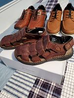 Three pairs of men's footwear: closed-toe brown Softmoc leather woven sandals and two pairs of Call It Spring dress shoes in brown and tan, displayed on a fabric surface.