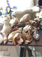 Full group of animal figurines displayed on a table, including dogs, cats, ducks, lions, and foxes.