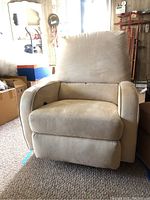 Front view of light beige rocking swivel recliner arm chair showing cushioned seat, backrest and armrests.