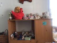 Wide view showing upper wooden shelf with various cat figurines, a large red polka dot chicken figure, and several ceramic cat pieces including a planter and mugs.