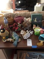 Overview of assorted ceramic and decorative items including squirrel cookie jar, animal figurines, rabbits, birds, and salt and pepper shakers.