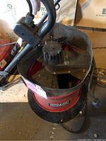 Photo of red cylindrical Flowtron Leaf Eater leaf mulcher showing the top motor housing and handle.