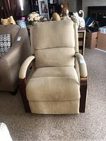 Front view of beige cloth rocker recliner with padded cushions and wooden armrests.