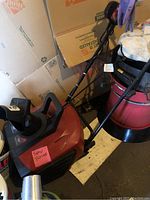 Full view of electric snow blower including handle and some nearby objects for scale.