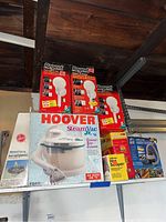 Lot showing Regent 3-in-1 outdoor lights in boxes, Hoover Steam Vac Jr in box, Wagner Hot Scraper in its box, wet dry vacuum visible behind