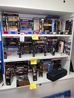 Full shelving with multiple VHS tapes stacked and arranged including The Godfather boxed set and other classics.