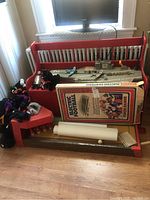Model aircraft carrier with two blue model airplanes displayed on a red bench, accompanied by Tudor Electric Football game box and assorted TY Beanie Babies plush toys on the side.