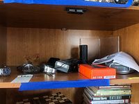 Wood shelf with multiple watches, electronics, and boxes displayed.
