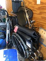 Full view of black Invacare 9000SL manual wheelchair showing padded seat, backrest, armrests, footrests and large rear wheels with push rims.