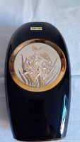 Full view of black ceramic vase with circular 24KT gold plated floral and butterfly design inset.