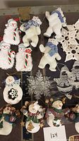 Photo showing knit and fabric snowmen, candy cane ornaments, crocheted snowflakes, and small decorative snowmen