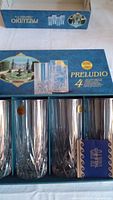 Set of 4 crystal rock glasses in Preludio Capri box showing detailed cut designs on the base, blue box with garden image.