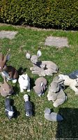Image showing 9 of the garden animal statues including rabbits, deer, dog, and skunks on grassy yard