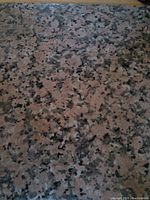 Close-up photo showing the speckled pattern and color of the granite tile surface.