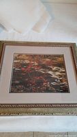 Full view of framed print showing autumn landscape with red maple leaves and water scene.