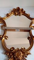 Full view of ornate gold framed mirror with ruler showing width